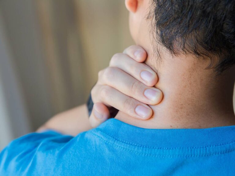 Człowiek z bólem kręgosłupa szyjnego. Obrazek w artykule Domowe sposoby na ból kręgosłupa szyjnego. Jak poradzić sobie z bólami kręgosłupa szyjnego?