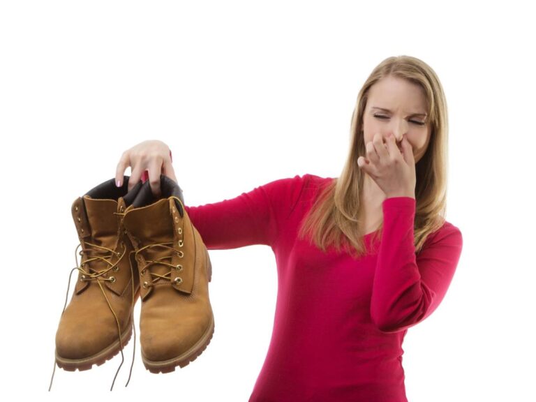 Kobieta z butami w rękach. Obrazek w artykule Sposób na śmierdzące buty. Sprawdzone metody eliminacji brzydkiego zapachu.