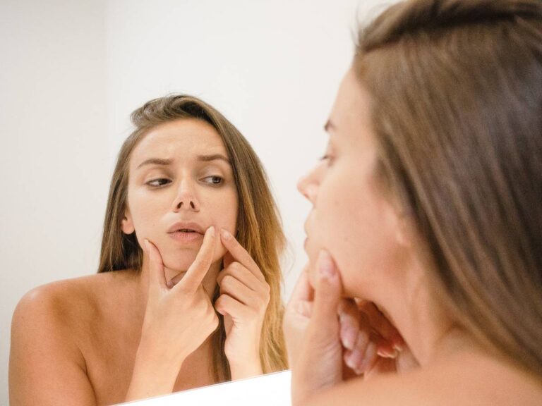 Kobieta przyed lustrem. Obrazek w artykule Sposób na wągry. Jak skutecznie pozbyć się wągrów?.