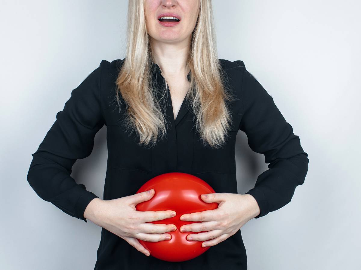 Kobieta demonstruje fantom wzdęć. Obrazek w artykule Szybki sposób na wzdęcia: naturalne sposoby łagodzące dyskomfort