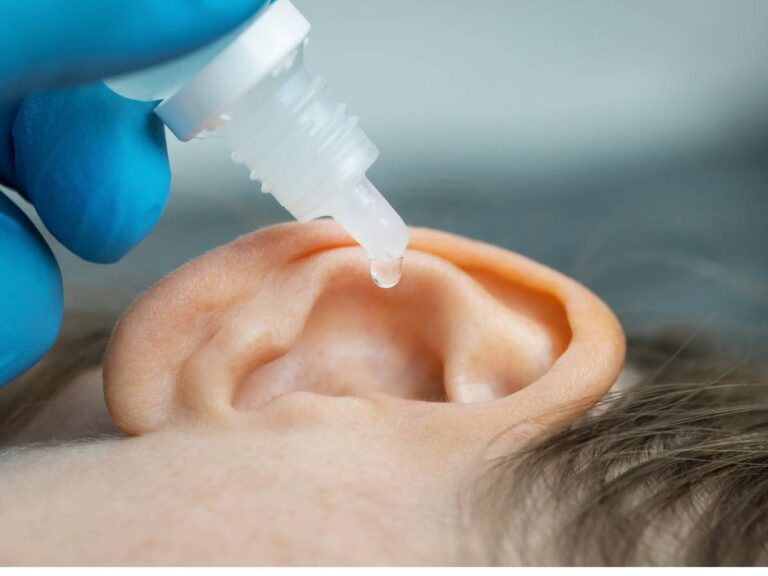 Wpuszczanie kropli do ucha. Obrazek w artykule Sposób na zatkane ucho. Skuteczne metody oczyszczania przewodu słuchowego.