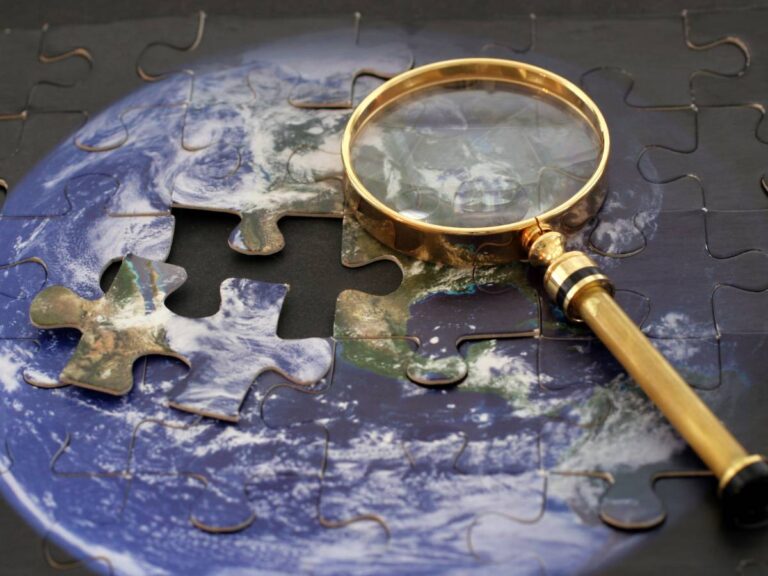 Lupa i mapa. Obrazek w artykule Podróżowanie jako sposób na poznanie świata i samego siebie: jak podróże pomagają nam rozwijać się i odkrywać nowe perspektywy