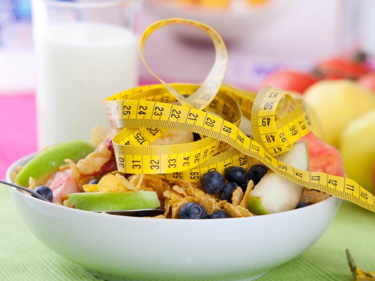 Taśma krawiecka i talerz z warzywami. Obrazek w artykule Odkwaszanie organizmu domowe sposoby. Jakie produkty pomagają w odkwaszaniu organizmu?